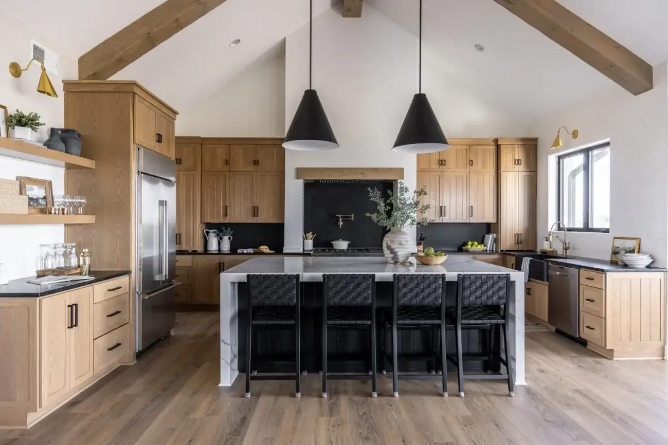 Modern white kitchen with brass fixtures and open shelving completed by Can Do More Renovations