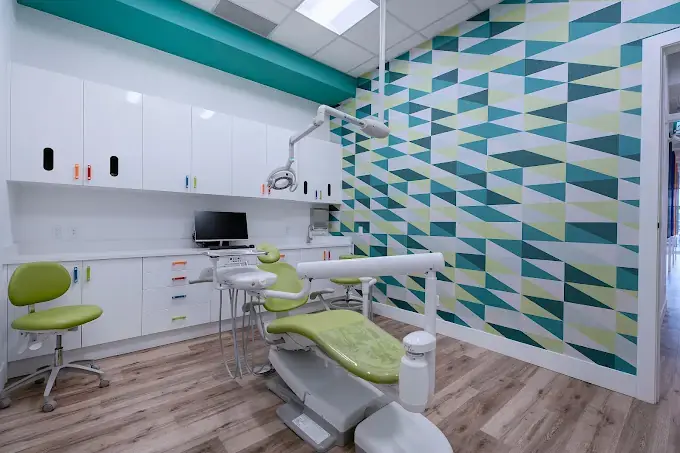 Dental operatory renovation with a green treatment chair and geometric feature wall in Calgary