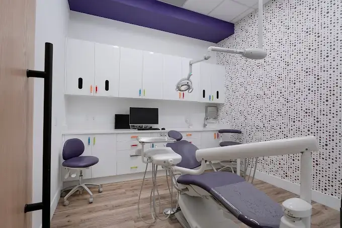 Dental operatory renovation with a purple treatment chair and patterned feature wall in Calgary