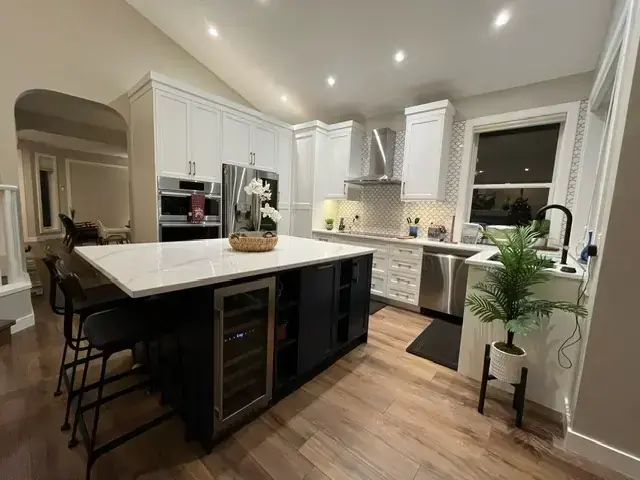 Santos kitchen after renovation with two-tone cabinetry and waterfall island