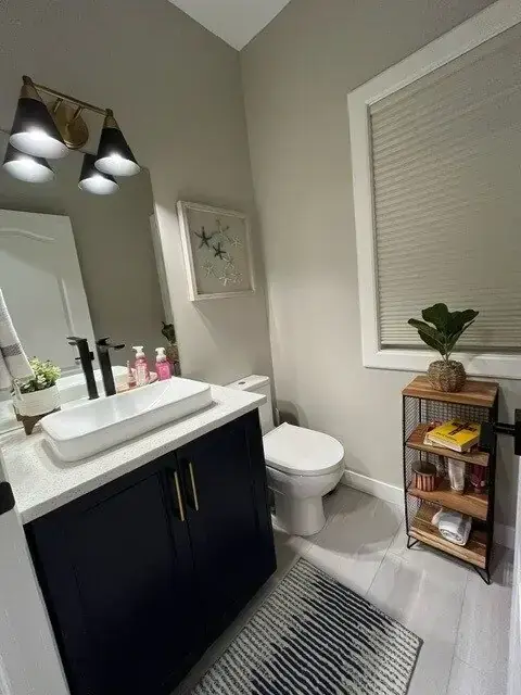 Santos main bathroom after renovation with navy vanity and quartz countertops